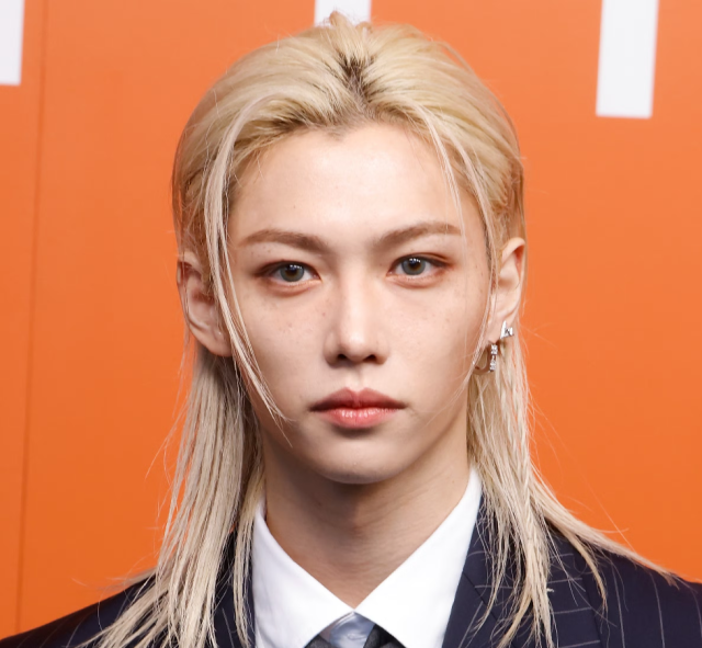 金髪の若い男性がスーツ姿で正面を見つめている写真