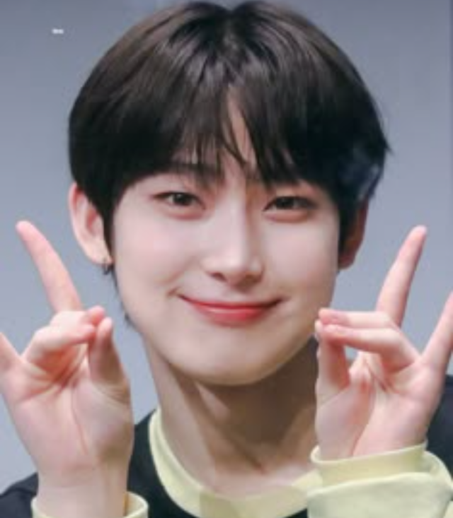 黒髪の若い男性が笑顔で両手の指を立てたポーズをしている顔写真