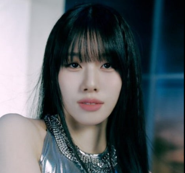 黒髪のロングヘアの若い女性が、メタリック調の衣装を着て正面を見つめている写真