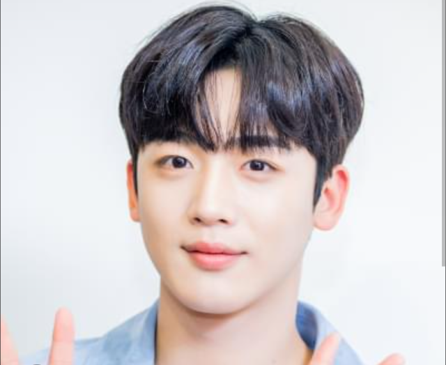 ヨハンの正面顔アップ画像。黒髪センターパートで明るい背景の前に立ち、やわらかい表情を見せている様子