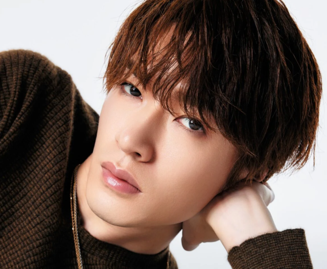 深澤辰哉の顔がよくわかるアップ画像。ブラウン系の髪で横になりながら、手を頭の後ろに添えてこちらを見つめている様子