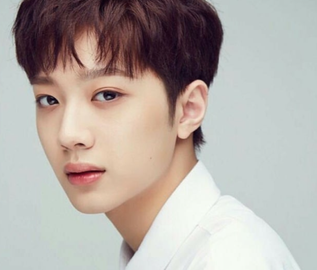 ライ・グァンリンの顔がよくわかるアップ画像。白いシャツ姿でやや横を向き、落ち着いた表情を見せている様子