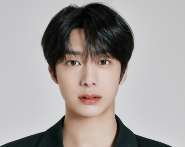 ヒョンウォンの正面顔画像。黒髪センターパートで、落ち着いた表情を見せている上半身アップ写真