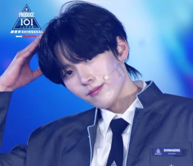 ステージ衣装姿のオ・シンヘンが片手を頭に添えて微笑む様子