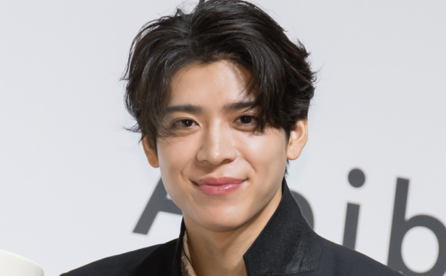 黒髪の人物が微笑みながら正面を向いているポートレート画像