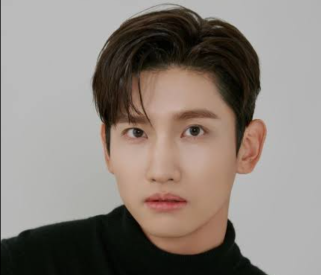 白い背景の前で、黒いタートルネックを着たチャンミンが正面を向いて写っているバストアップ画像。大きな目元と整った口元、上品な雰囲気が印象的です。