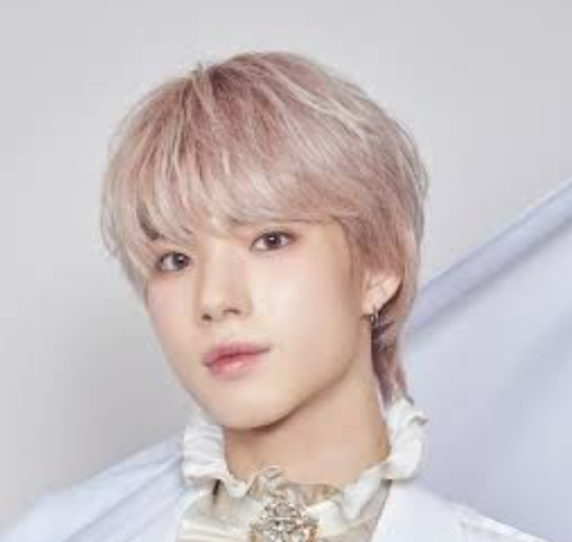 淡いピンクベージュの髪色の人物が白い衣装を着てこちらを見つめているバストアップ画像