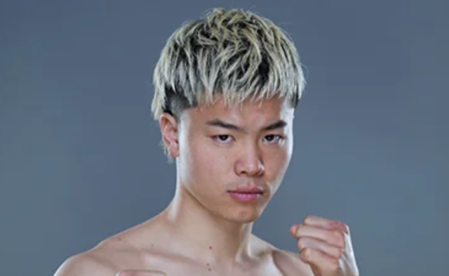 ファイティングポーズを取る那須川天心の上半身画像。短めの明るいヘアスタイルと鋭い目元が印象的な写真